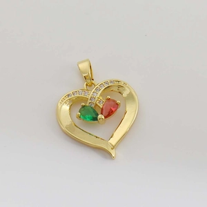 Détail du pendentif cœur avec gemmes vertes et rouges et sertissage de zircons