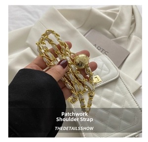 Detail of white leather and gold metal chain strap with adjustable gold ball charm