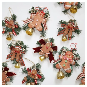 Detailed view of gingerbread man Christmas ornaments with pine needles and golden bells