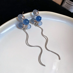 Detail of silver wavy snake chains and blue frosted bead floral cluster earrings