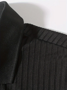 Close-up of black polo shirt neckline showing vertical ribbed texture and stitching detail