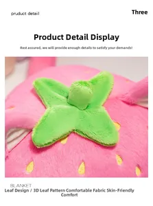 Detail of pink strawberry plush blanket featuring realistic texture and green leaf design