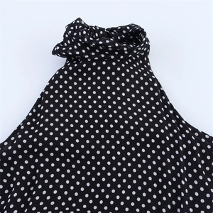 Close-up detail of the polka dot fabric and halter neckline on this sleeveless women's top