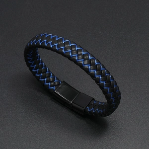 Dettaglio di un bracciale intrecciato in pelle nera e fibra blu con chiusura magnetica