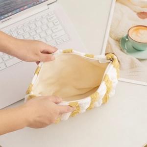 Detail view of the yellow checkered puffer cosmetic bag showing spacious beige interior