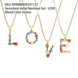 Close-up of four gold necklaces featuring L-O-V-E pendants with colorful zircon stones