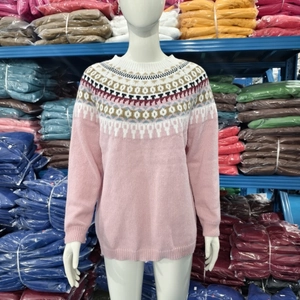 Detail view of pink knitted sweater showing ethnic jacquard pattern and ribbed cuffs