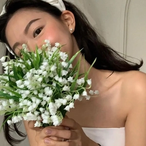 Close-up of white pleated headband and elegant round pearl earrings on a female model