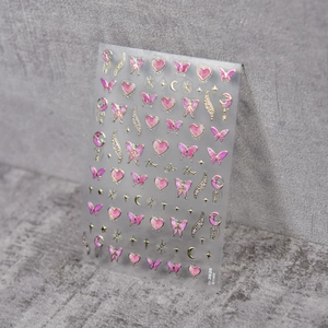 Detail of 3D embossed nail art stickers with gold stars, moon, and pink butterflies