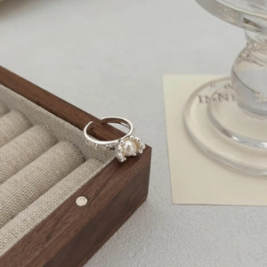 Detail of adjustable 925 silver ring with central white pearl and hammer finish texture