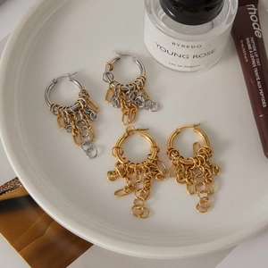 Detail of minimalist mixed metal chain tassel earrings in gold and silver finish