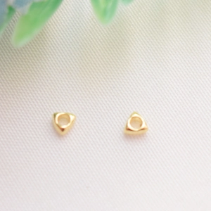 Macro detail of 14k gold-filled triangular spacer beads for DIY jewelry making