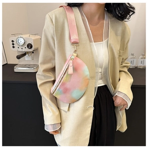 Rainbow gradient crossbody bag with lychee texture and pink strap worn over a beige suit