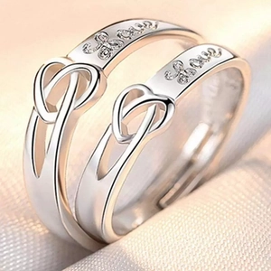 Macro shot of silver couple rings with Love engraving and heart infinity symbol