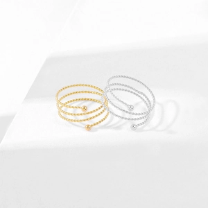 Dettaglio di anelli a spirale multistrato in titanio oro e argento con sfere finali