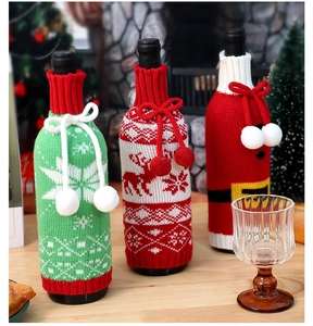 Detailed view of knitted Christmas wine bottle covers with elk and snowflake patterns