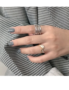 Detailed view of stacked silver multi-layer and gold wavy rings on a hand
