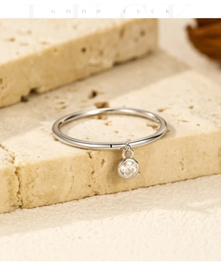 Detail view of S925 sterling silver ring with a hanging round moissanite pendant