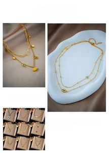 Detailed close-up of gold-plated necklaces with heart, eye, and star pendants on silk fabric