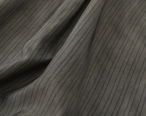 Detailed view of high-quality dark grey pinstripe fabric with soft texture and drape