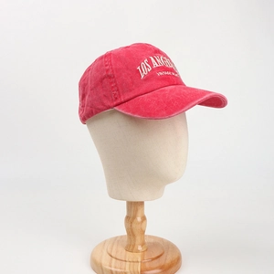 Detailed close-up of Los Angeles white embroidery on vintage washed red cotton cap