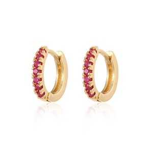 Detailed view of gold plated hoop earrings with channel set vibrant red cubic zirconia