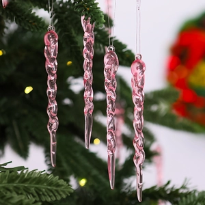 Pink twisted icicle ornaments hanging on a green Christmas tree with warm bokeh