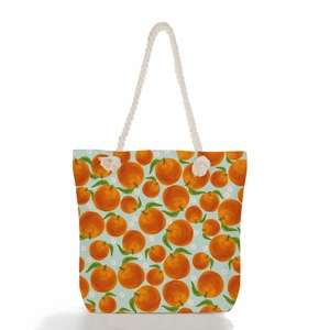 Close-up of summer beach bag with orange fruit print and durable rope handles