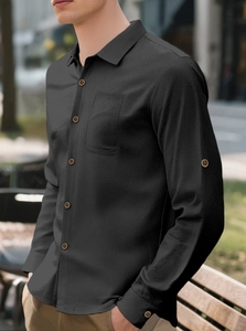 Detail of black linen shirt showing fine fabric texture, buttons and chest pocket