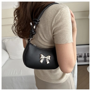 Fashionable black leather shoulder bag with silver bow accent and knot strap detail