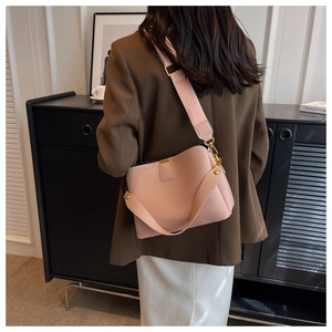 Detail of pink lychee textured bucket bag with golden metal hooks and two straps