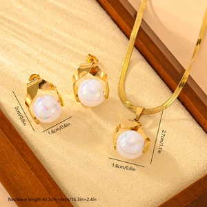 Elegant gold pearl jewelry set including necklace and earrings on a wooden tray