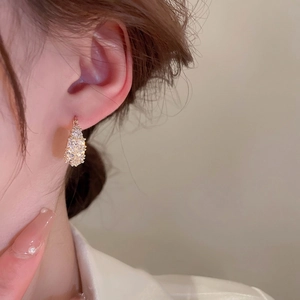 Gold plated teardrop earrings with pave zircons shown on model for elegant styling