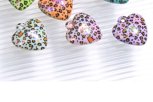 Macro shot of colorful leopard print heart charms with top holes for DIY jewelry making