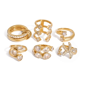 Set of six gold stainless steel rings featuring starfish and zircon stones on white background