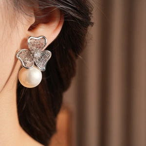 Detailed view of vintage silver clover earrings with zircon center and hanging pearl charm
