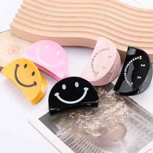 Set of acrylic smiley face hair claws in yellow, pink and black with rhinestone details