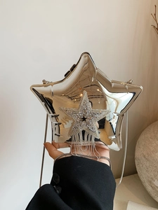 Detail of silver acrylic star bag with sparkling rhinestone fringe and metal chain strap