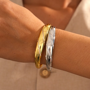 Close-up of 18k gold plated and silver twisted bangles with zircon inlay on wrist
