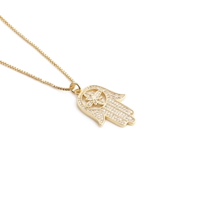 Golden Hamsa Hand pendant necklace with white crystals on a minimalist box chain