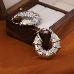 Modern hollow stainless steel hoop earrings with pleated texture in silver finish