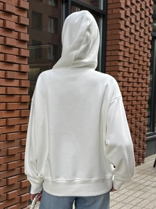 Close-up of white street style hoodie featuring ribbed cuffs and thick cotton fabric texture