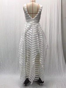 Dettaglio dell'abito da sposa bianco senza schienale in pizzo con scollo a V e orlo