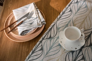 Linen plaid table runner with leaf pattern, styled with dinnerware and ceramic cup