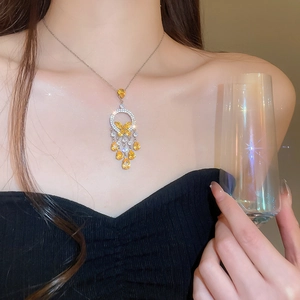 Detail of silver necklace with butterfly pendant and yellow teardrop tassel gemstones