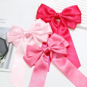 Three-piece layered satin bow hair clips in shades of pink with elegant long ribbons