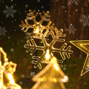 Solar powered Christmas garden stake lights with LED stars and snowflakes in warm glow