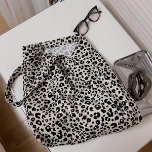 Vista piatta di una borsa tote in tela leopardata con occhiali e accessori moda