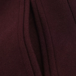 Detail shot of the burgundy wool blend coat fabric showing thick texture and stitching