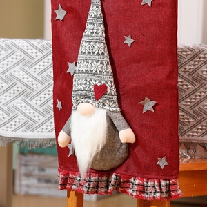 Detail view of red Christmas chair cover with festive 3D gnome and buffalo plaid trim